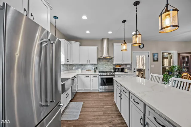 a kitchen with stainless steel appliances granite countertop a refrigerator a sink and a stove