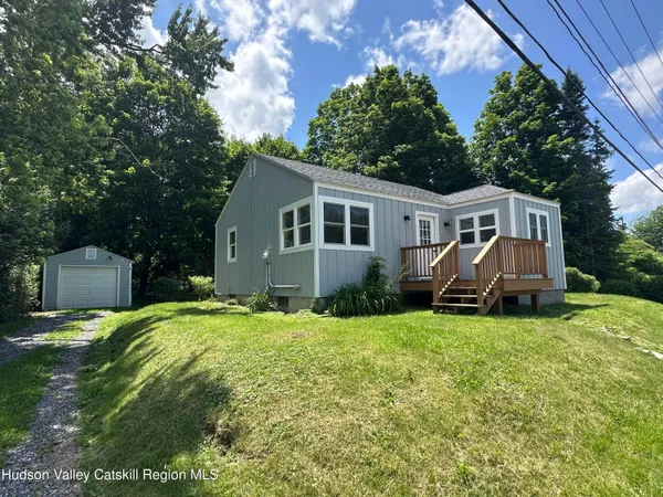 a view of a house with a yard and sitting area