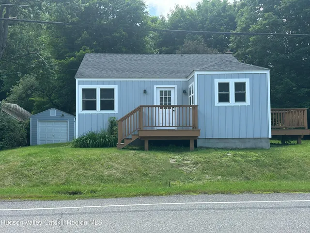 a house that is sitting in the grass with wooden fence