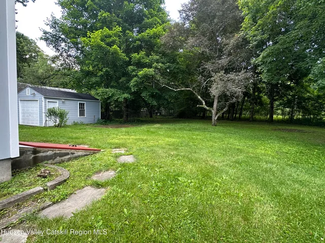 a view of a backyard with table and chairs and wooden fence