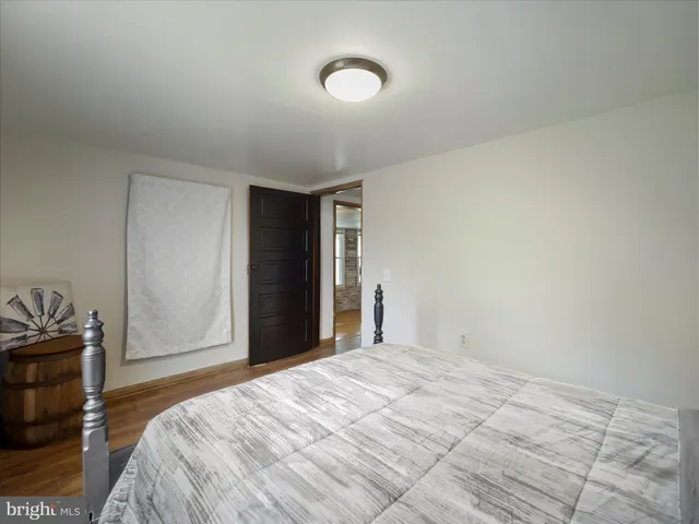 a kitchen with stainless steel appliances kitchen island granite countertop a refrigerator a stove a sink dishwasher and white cabinets with wooden floor