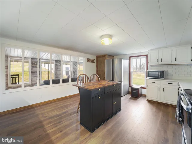 a kitchen with granite countertop a sink a counter space appliances and cabinets