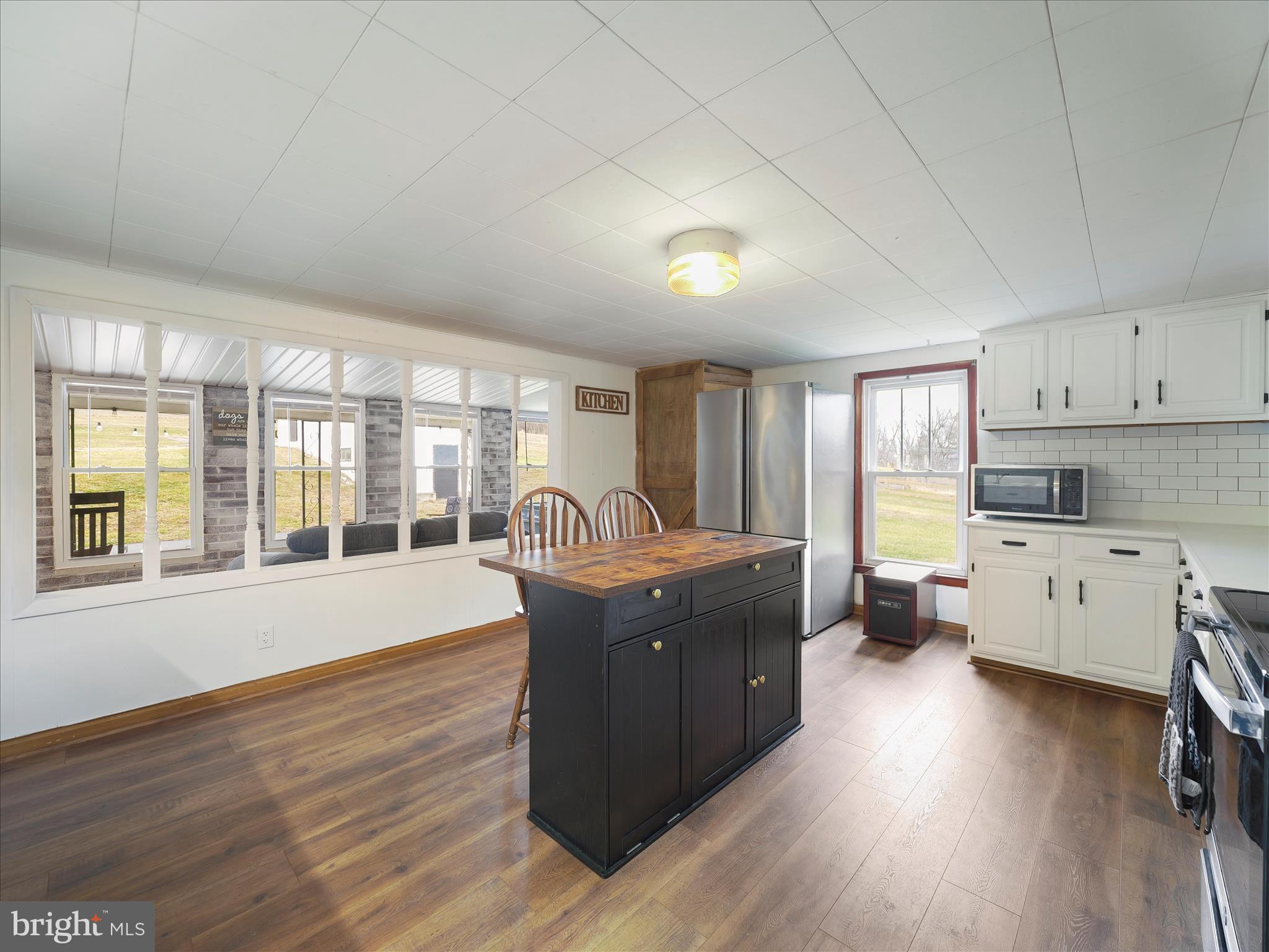 14628 Hollow Road Hancock, MD 21750 - Photo 14 of 54 a room with kitchen island granite countertop wooden floors and white stainless steel appliances