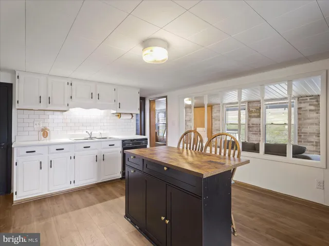 a kitchen with stainless steel appliances granite countertop a white cabinets and wooden floor