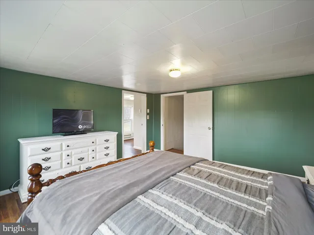a view of a bedroom with furniture and wooden floor