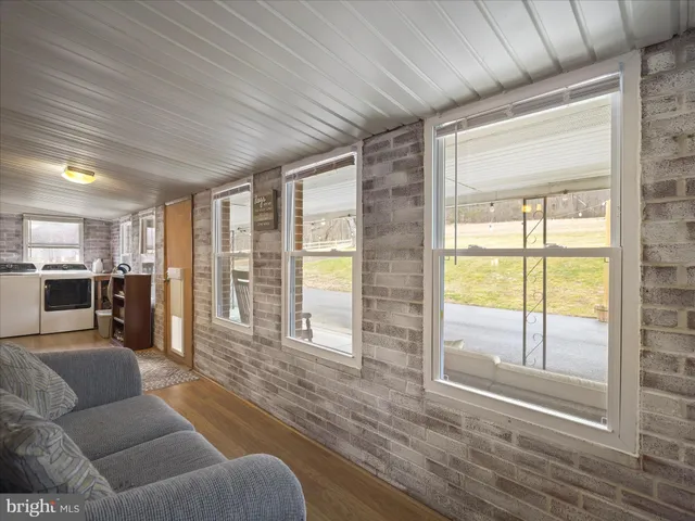 a bed sitting in a bedroom next to a window and a chair