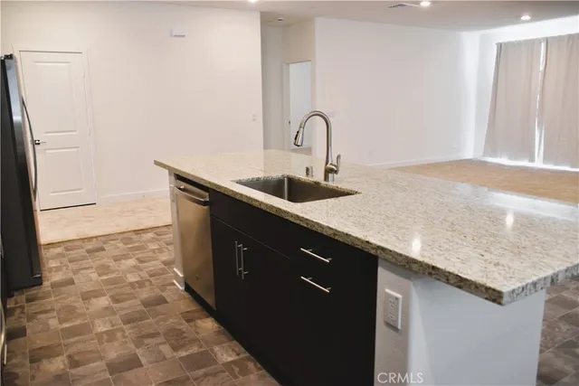 a close view of a sink a counter top space and cabinets