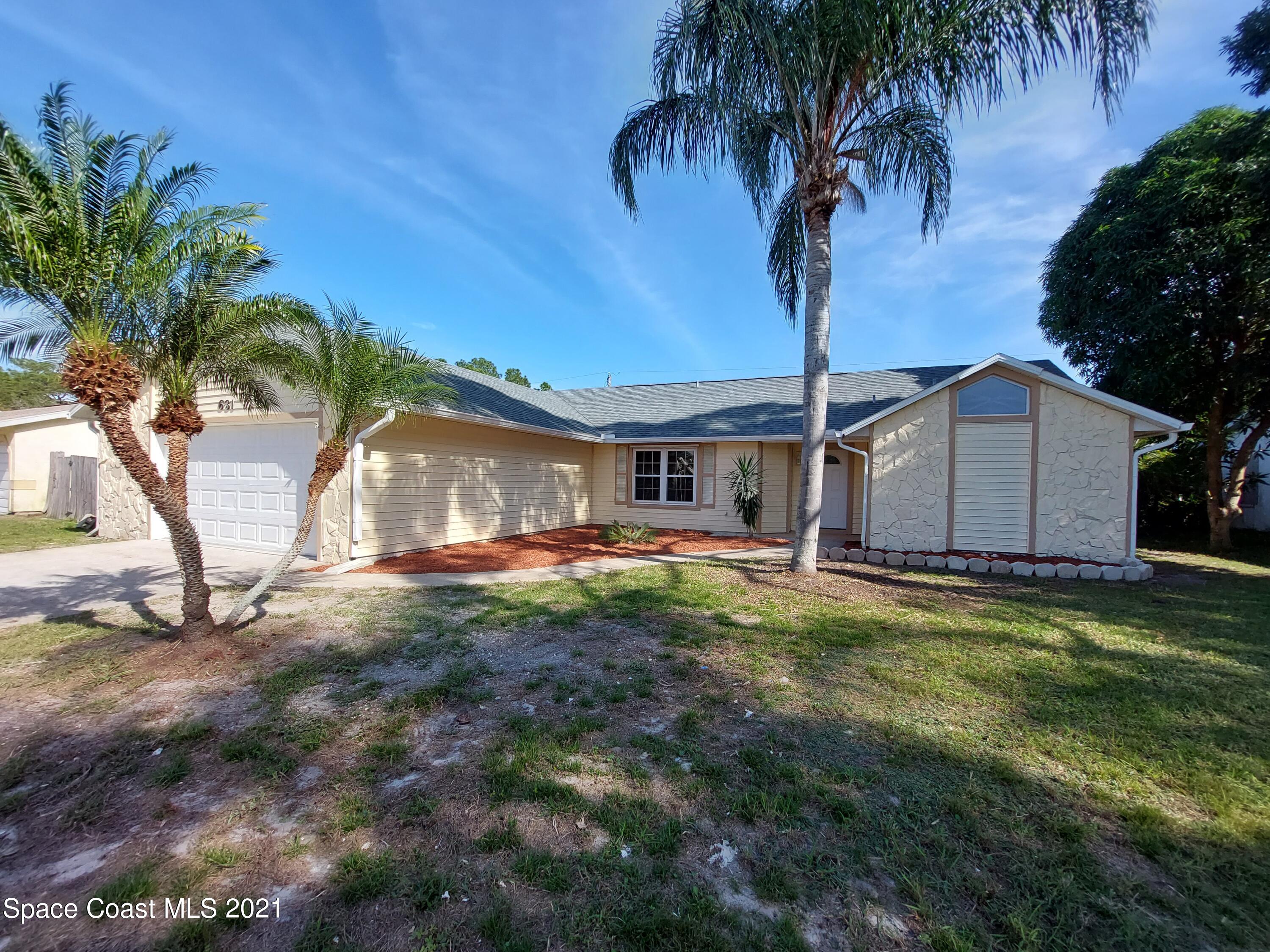 631 Furth Road Northwest Palm Bay, FL 32907 - Photo 2 of 42 a backyard of a house with table and chairs plants and large tree