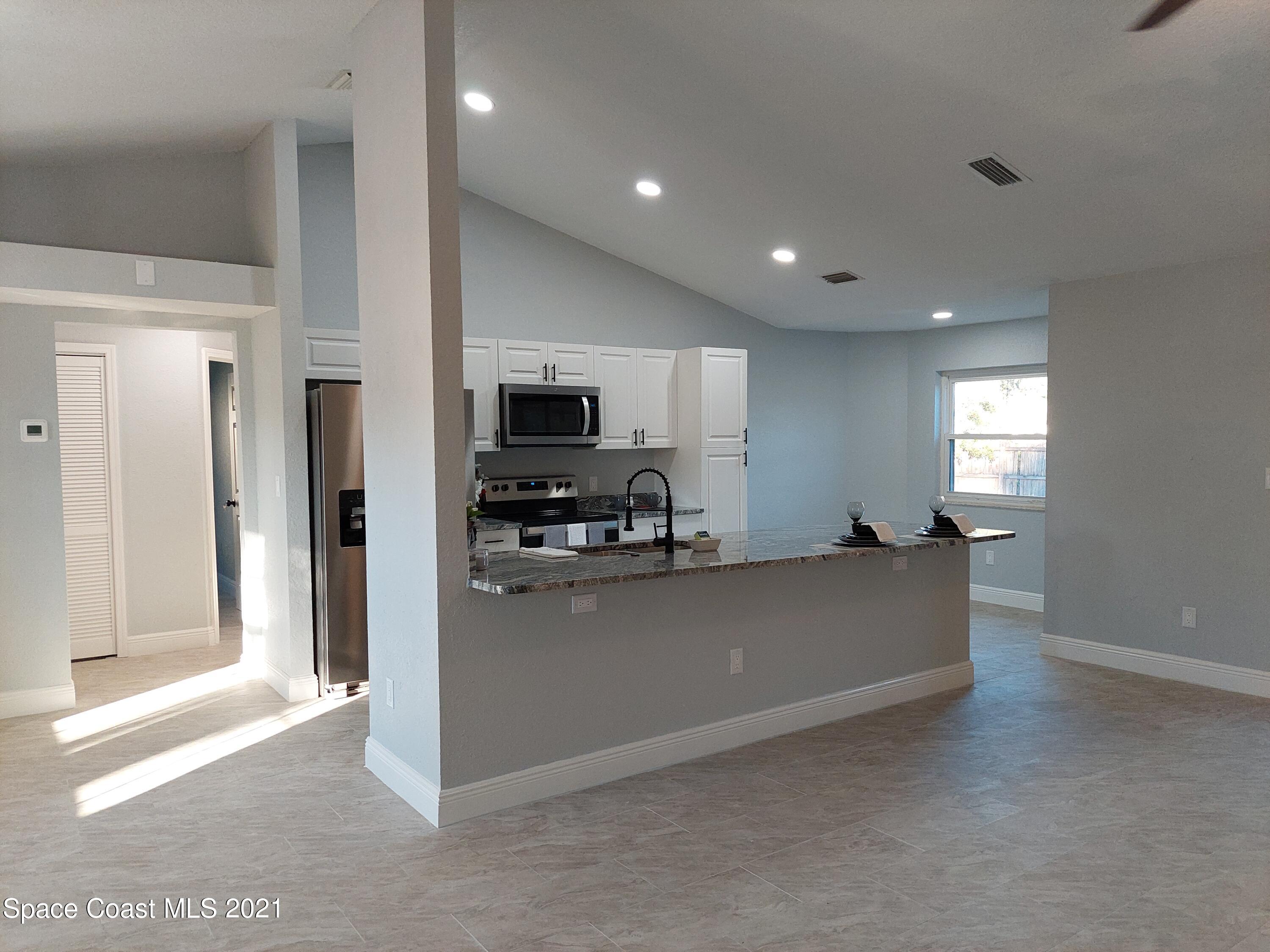 631 Furth Road Northwest Palm Bay, FL 32907 - Photo 11 of 42 a living room with stainless steel appliances furniture a window and a view