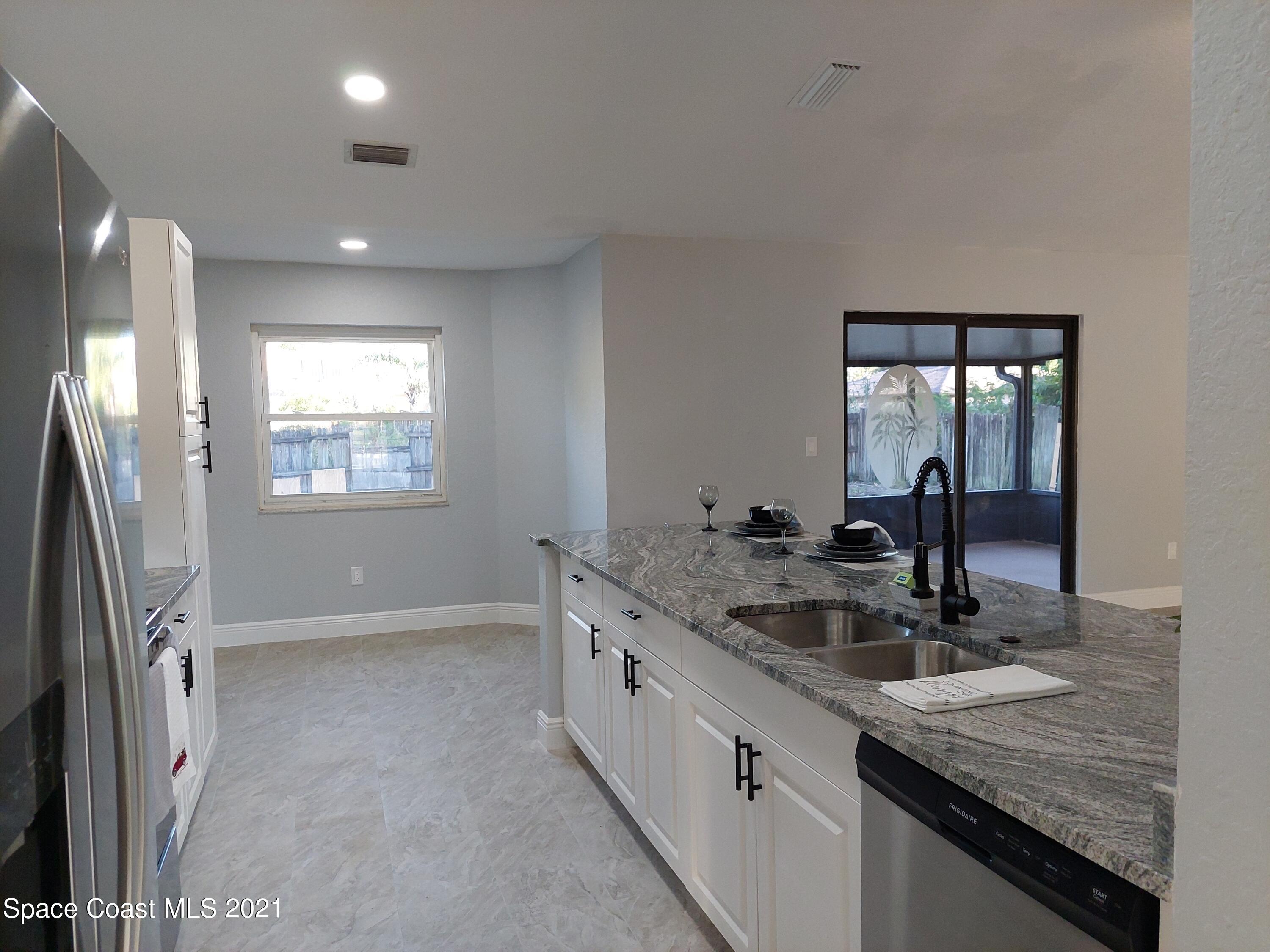 631 Furth Road Northwest Palm Bay, FL 32907 - Photo 12 of 42 a kitchen with granite countertop a sink and a refrigerator