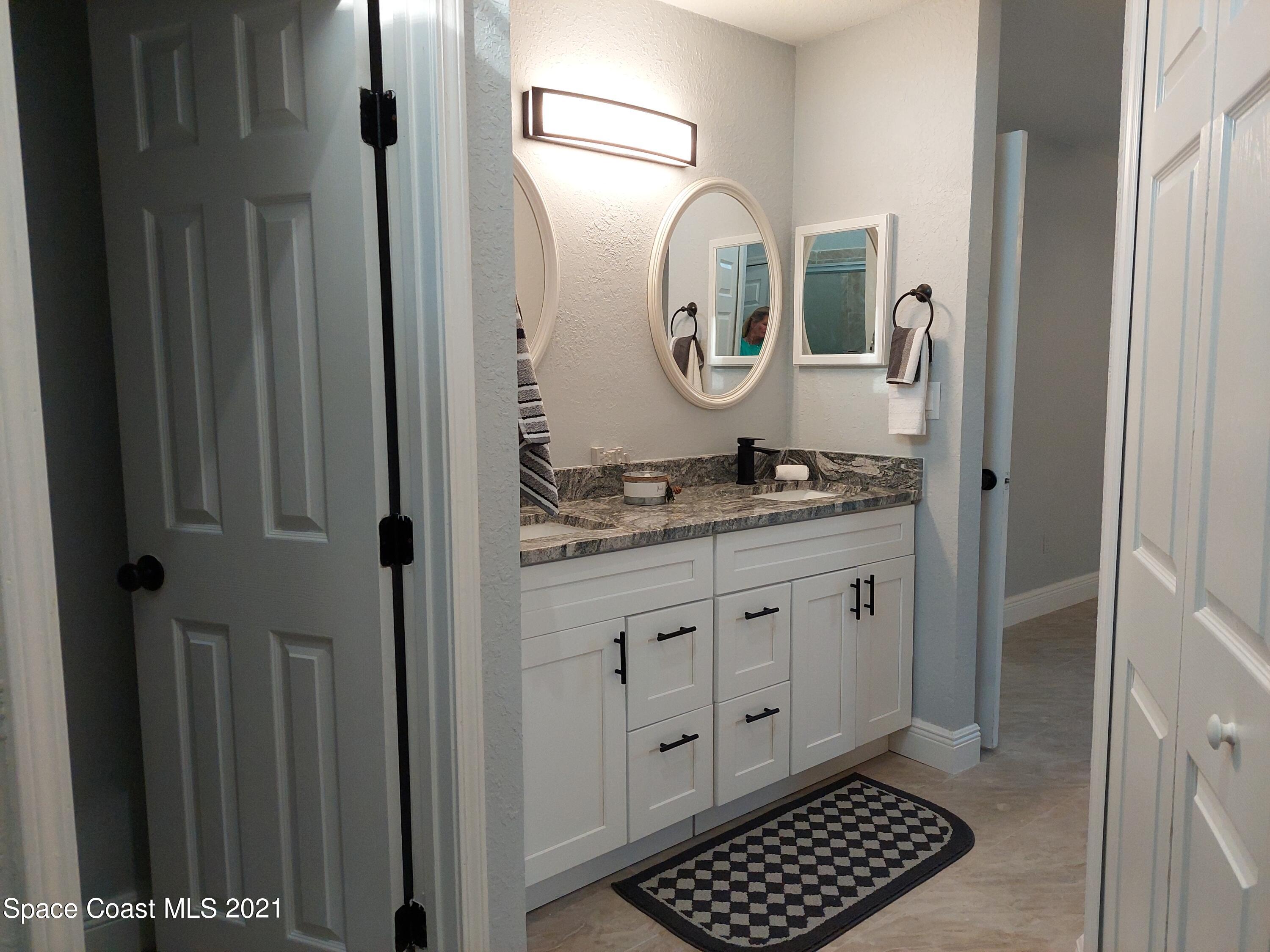 631 Furth Road Northwest Palm Bay, FL 32907 - Photo 16 of 42 a bathroom with a granite countertop sink mirror and vanity