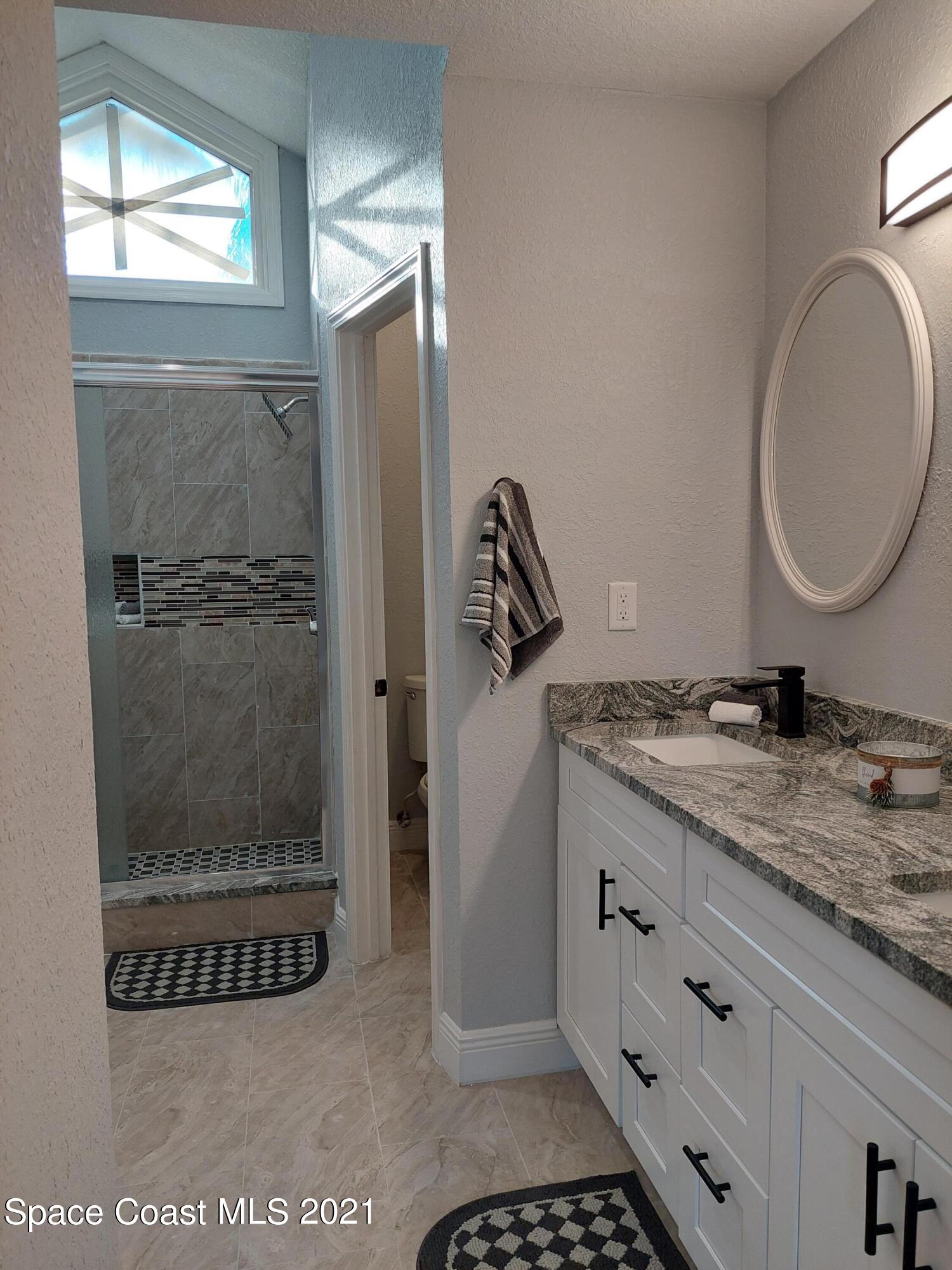 631 Furth Road Northwest Palm Bay, FL 32907 - Photo 22 of 42 a bathroom with a granite countertop sink mirror and vanity