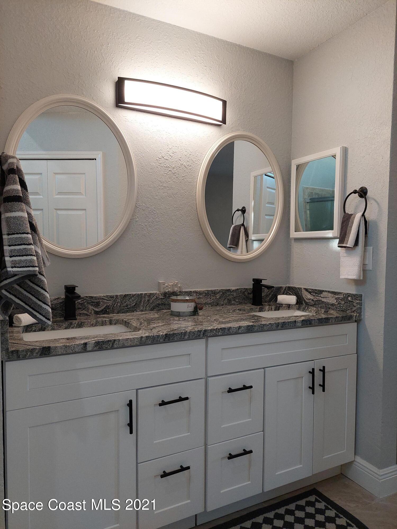 631 Furth Road Northwest Palm Bay, FL 32907 - Photo 23 of 42 a bathroom with a granite countertop double vanity sink and mirror