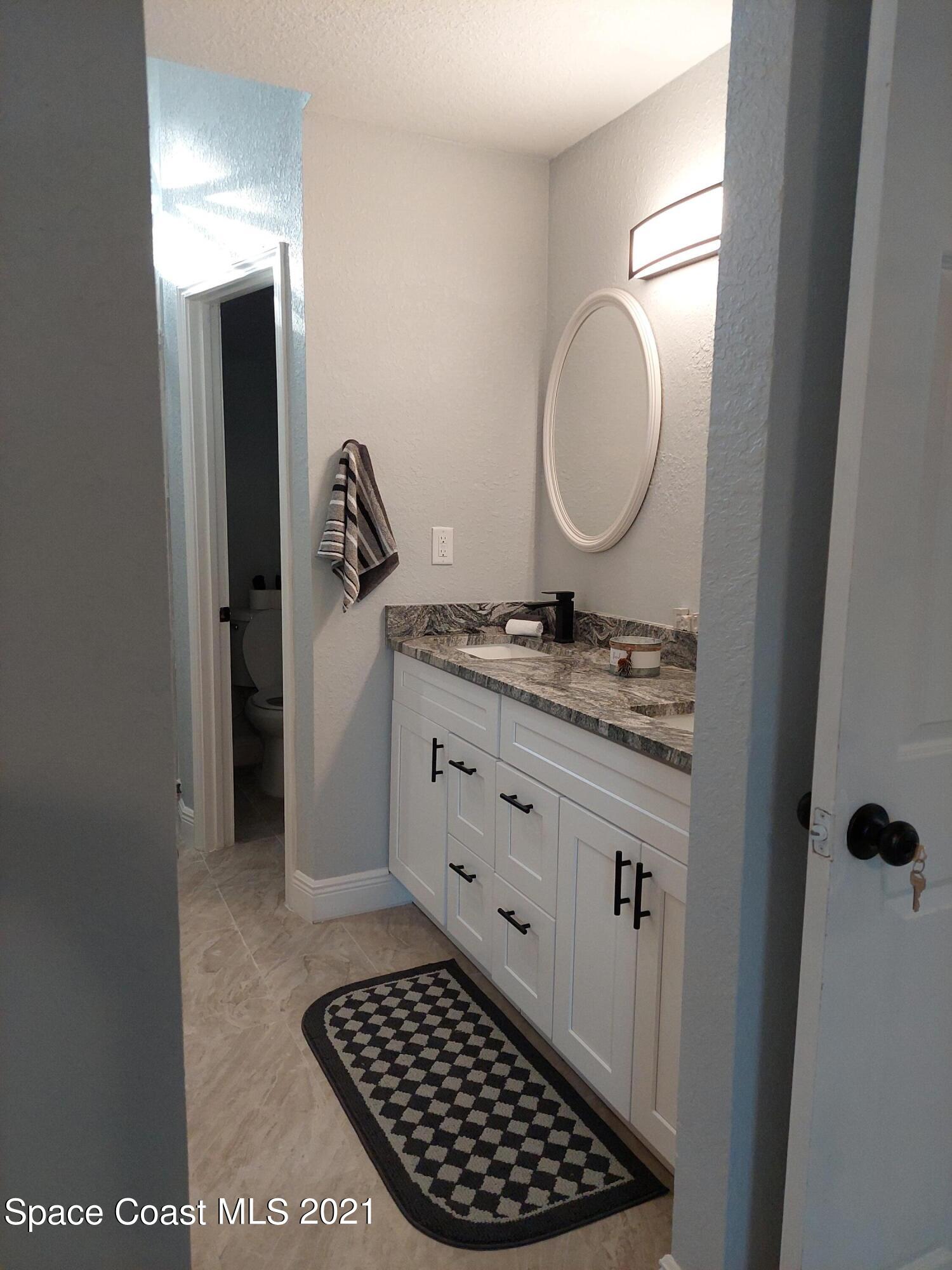 631 Furth Road Northwest Palm Bay, FL 32907 - Photo 25 of 42 a bathroom with a mirror and a sink