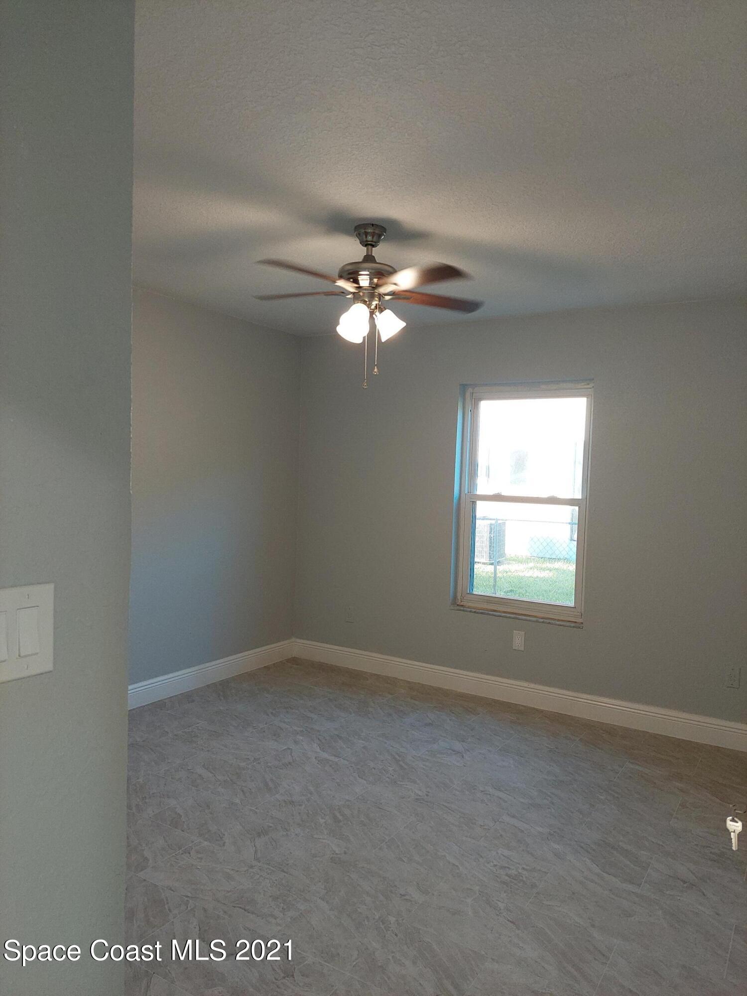 631 Furth Road Northwest Palm Bay, FL 32907 - Photo 26 of 42 an empty room with a window and a ceiling fan