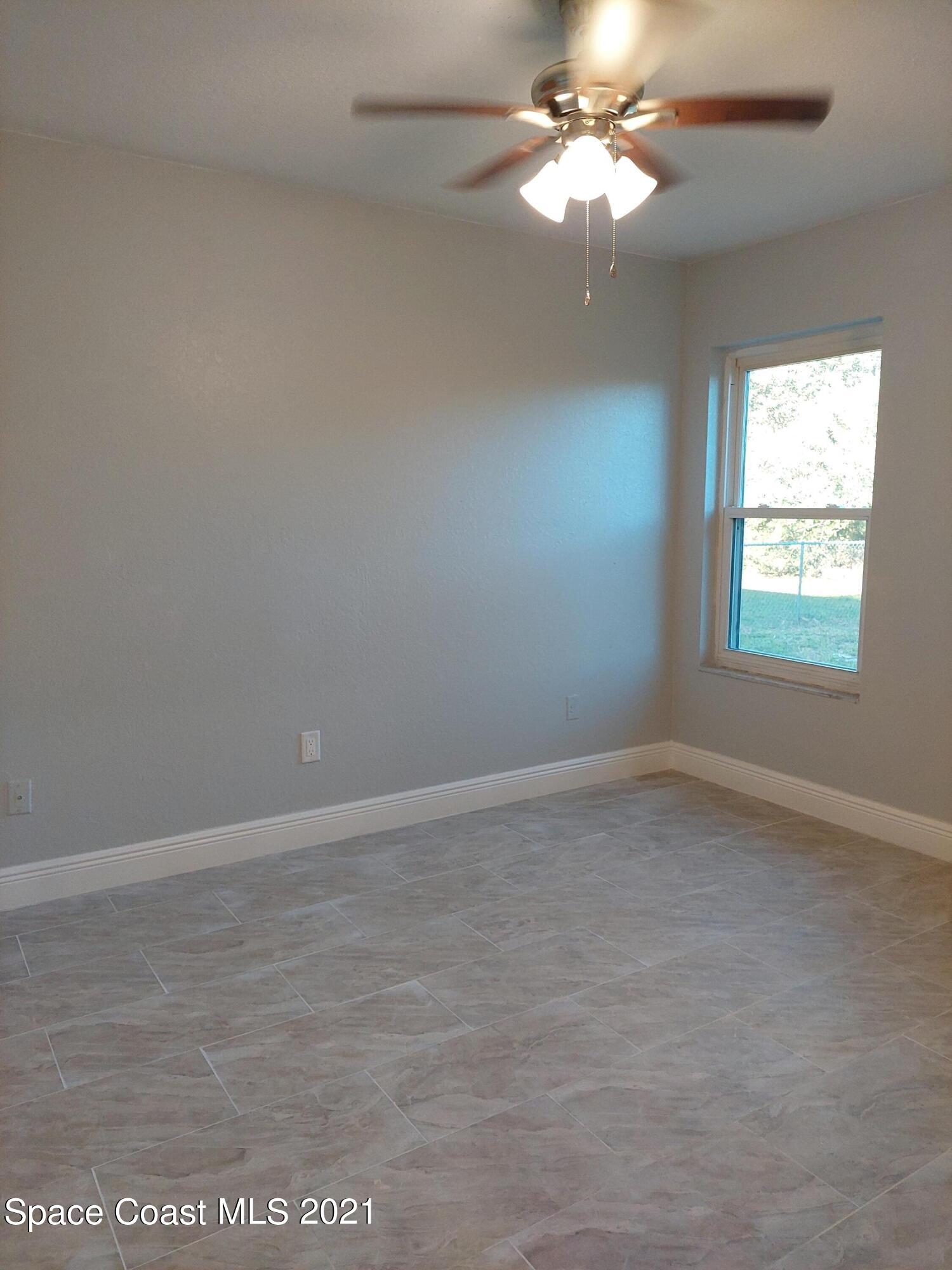 631 Furth Road Northwest Palm Bay, FL 32907 - Photo 29 of 42 an empty room with a window and a fan