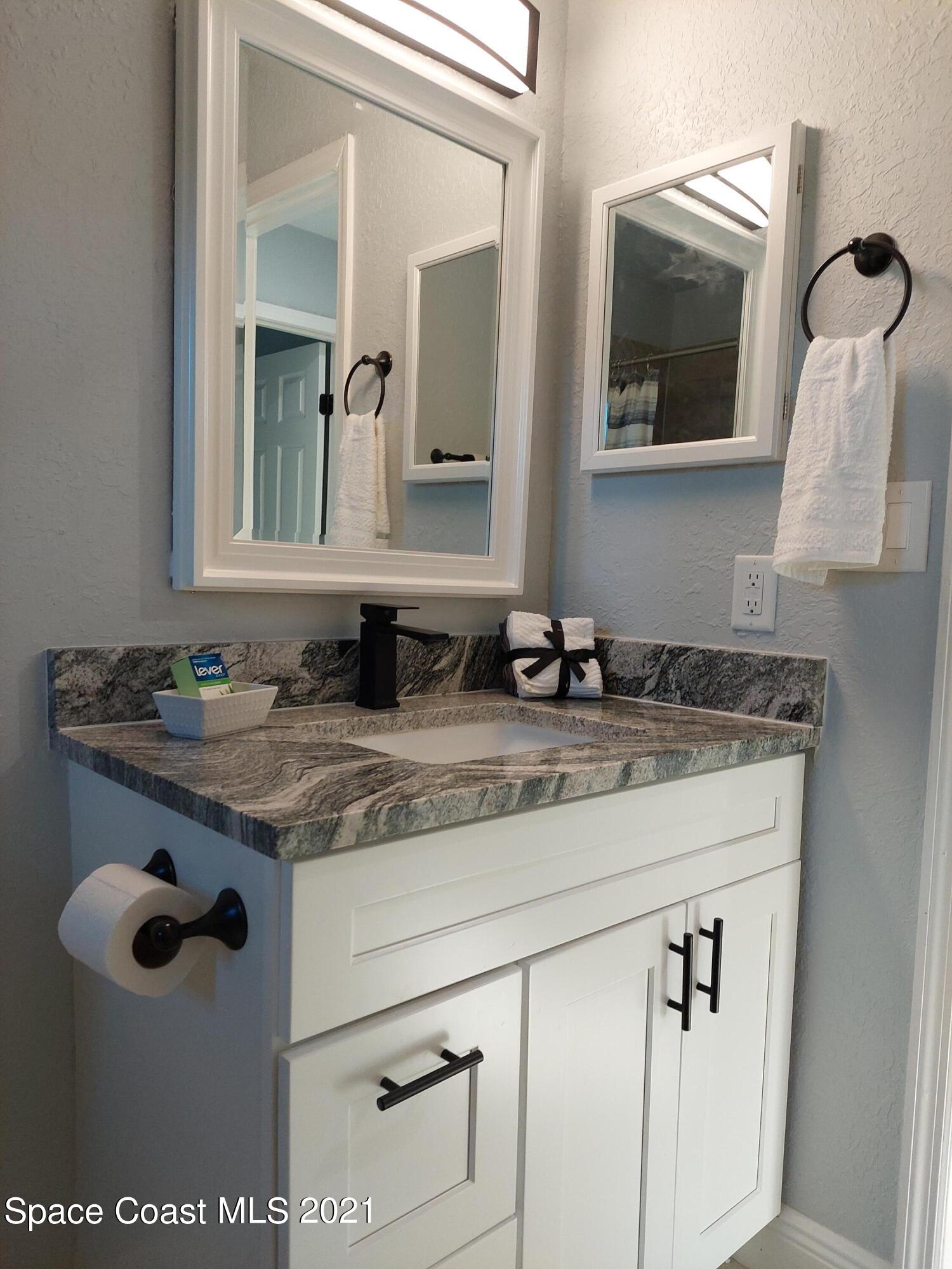 631 Furth Road Northwest Palm Bay, FL 32907 - Photo 32 of 42 a bathroom with a granite countertop sink and a mirror