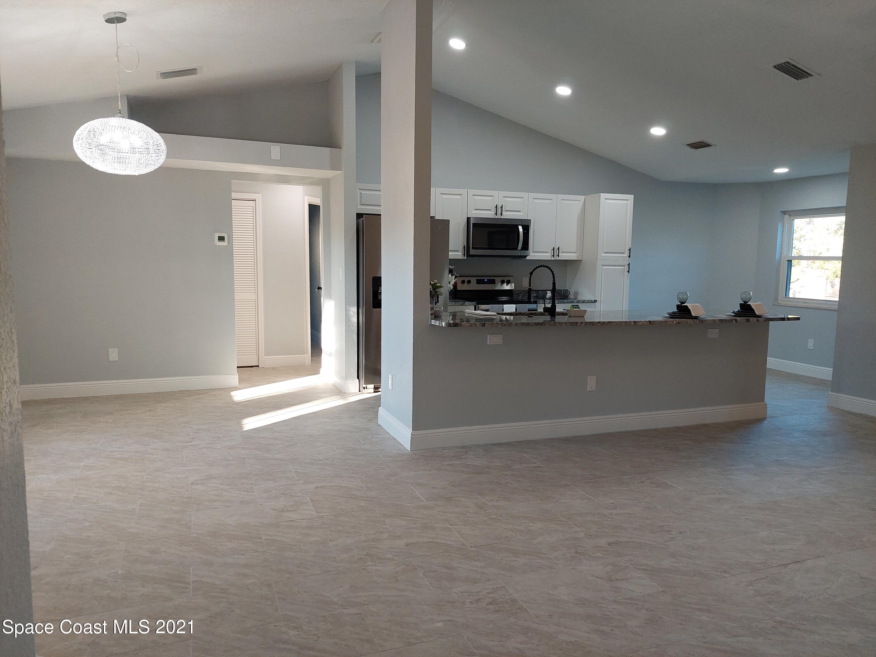 631 Furth Road Northwest Palm Bay, FL 32907 - Photo 7 of 42 a view of a kitchen with furniture and a flat screen tv