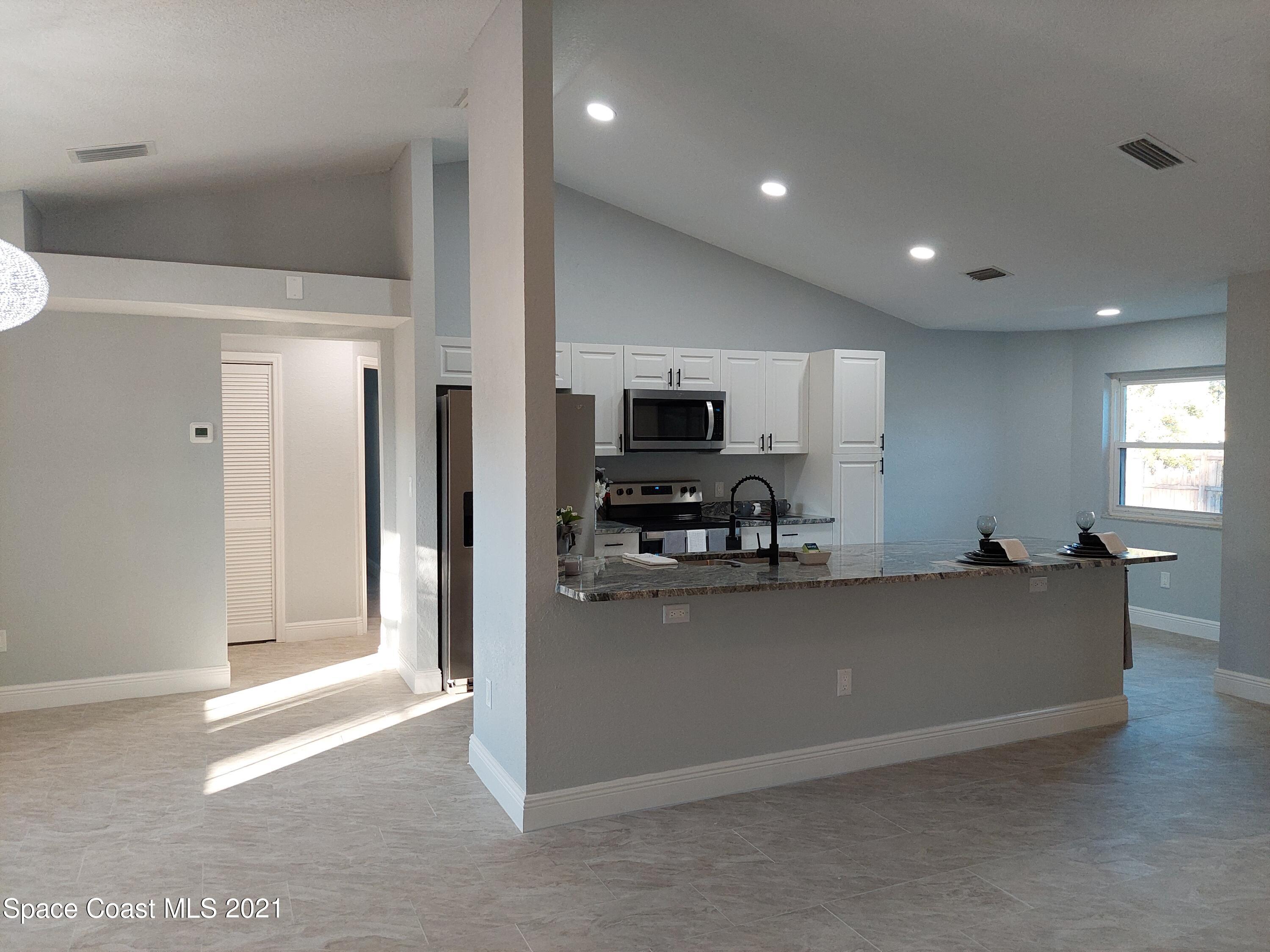 631 Furth Road Northwest Palm Bay, FL 32907 - Photo 8 of 42 a kitchen with stainless steel appliances a refrigerator sink and microwave