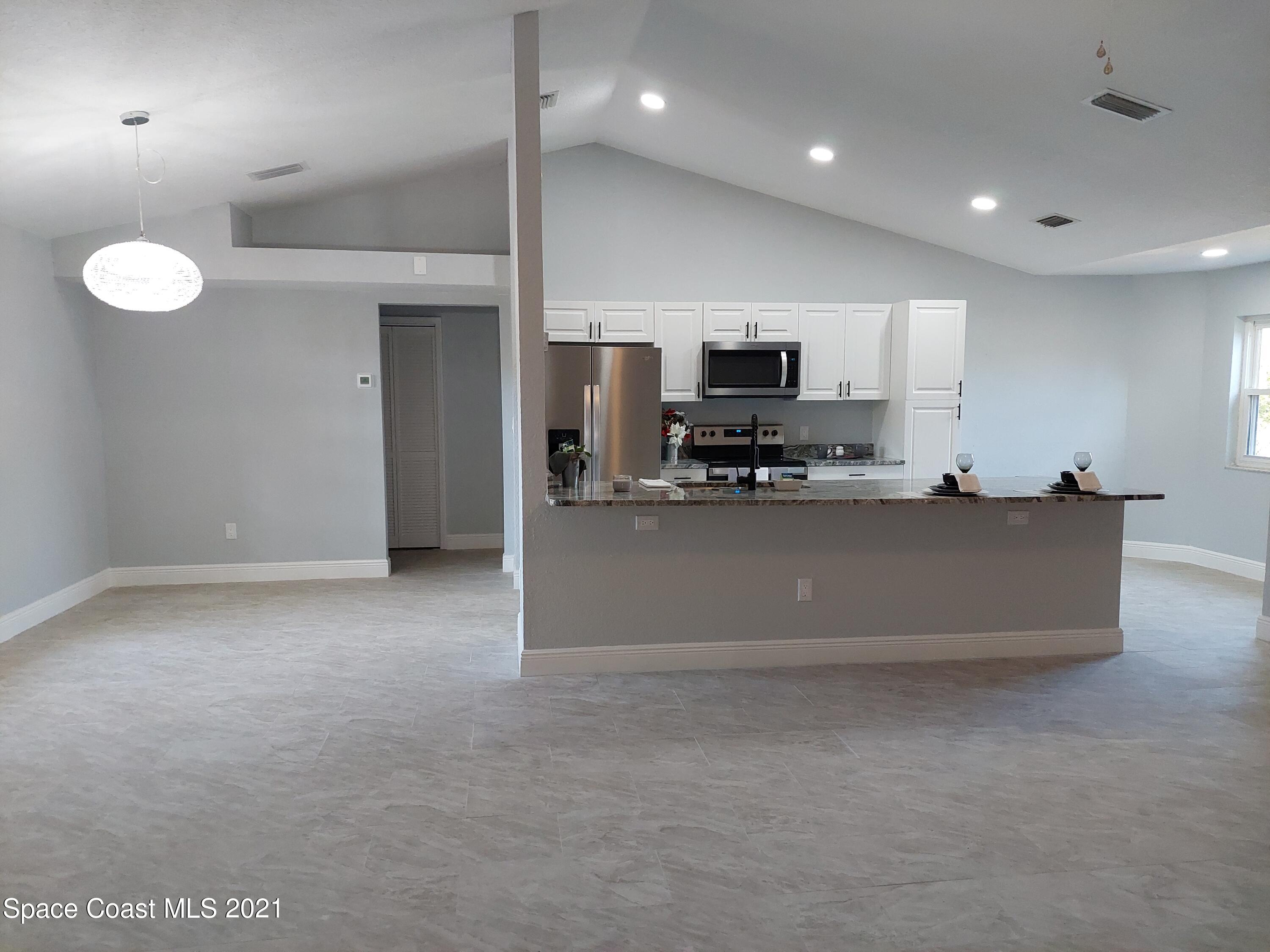631 Furth Road Northwest Palm Bay, FL 32907 - Photo 10 of 42 a large kitchen with a large counter top stainless steel appliances and cabinets