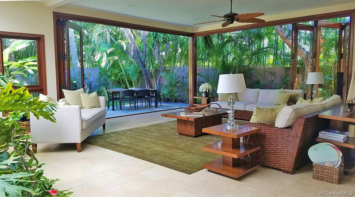 a living room with patio furniture and garden view