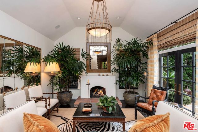 a living room with furniture a fireplace and a potted plant