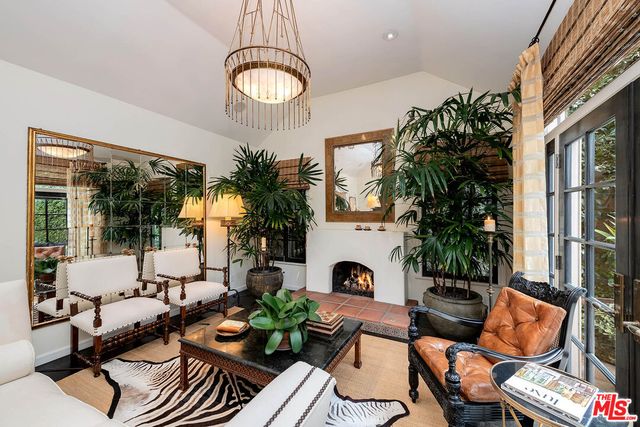 a living room with furniture a chandelier and a fireplace