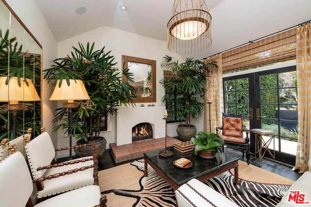 a living room with furniture a chandelier and a fireplace