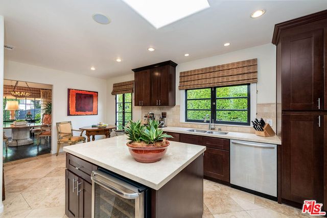 a kitchen with a sink stainless steel appliances and view living room