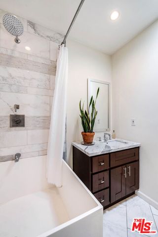 a bathroom with a tub sink and mirror