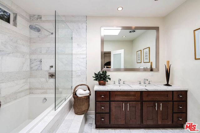 a bathroom with a tub sink and mirror