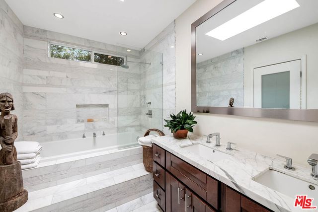 a bathroom with a granite countertop sink mirror and bathtub