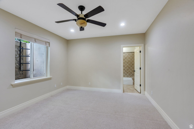 650 East Center Street Alpine, UT 84004 - Photo 26 of 38 One of two bedrooms in basement featuring ceiling fans with integrated lighting, recessed ceiling lights, a window with a stone-lined window well, and an ensuite bathroom with tiled shower and flooring