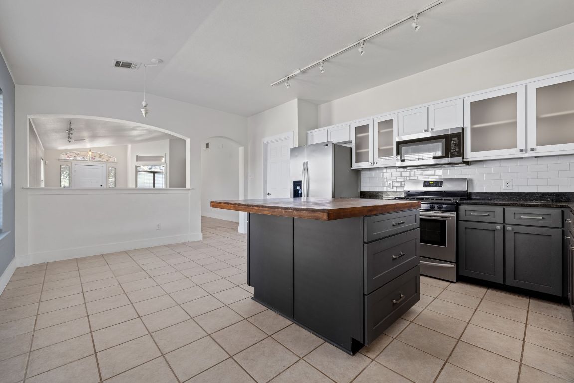 9324 Muskberry Cove Austin, TX 78717 - Photo 11 of 26 a kitchen with stainless steel appliances granite countertop a stove and a sink