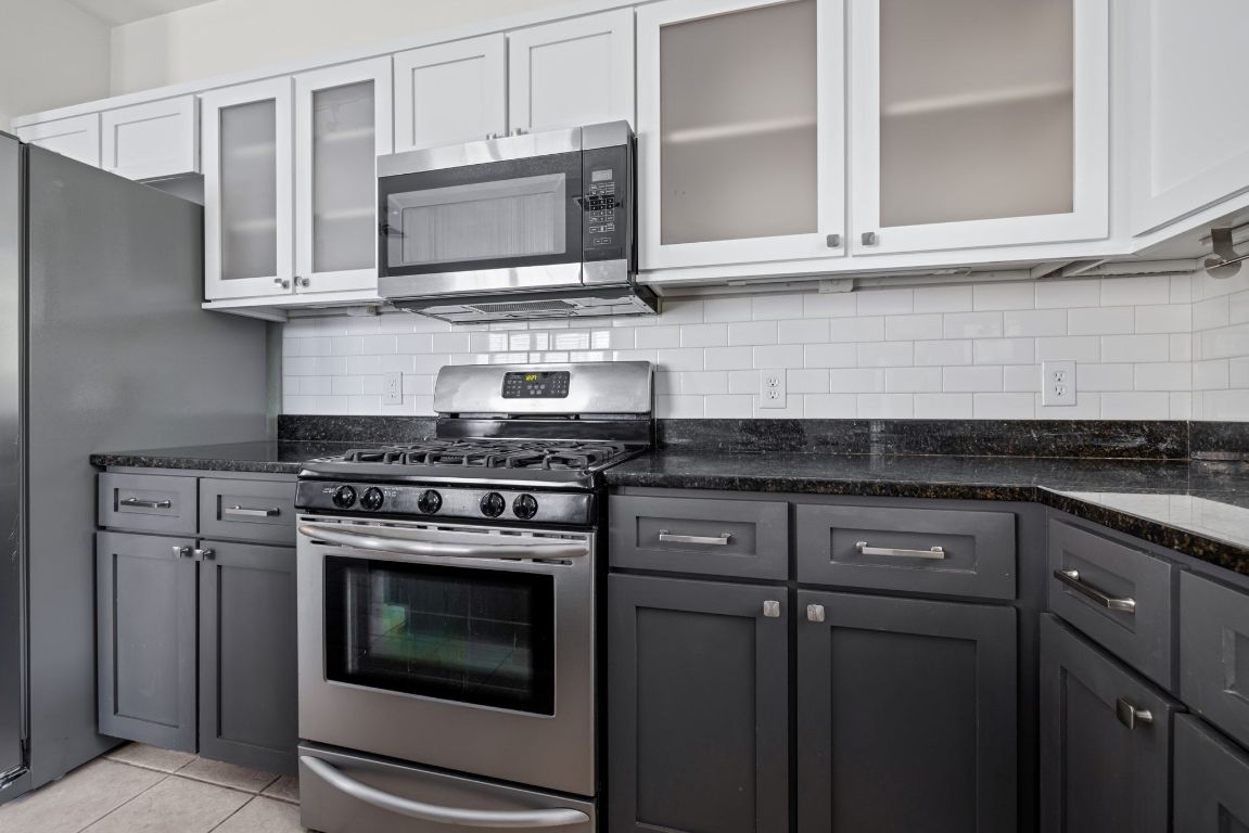 9324 Muskberry Cove Austin, TX 78717 - Photo 12 of 26 a kitchen with stainless steel appliances granite countertop white cabinets and a stove top oven