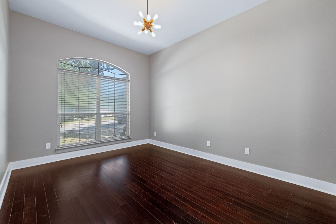 9324 Muskberry Cove Austin, TX 78717 - Photo 7 of 26 a view of an empty room with wooden floor and a window