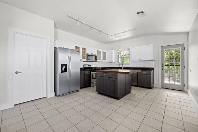 a kitchen with stainless steel appliances granite countertop a refrigerator and a sink