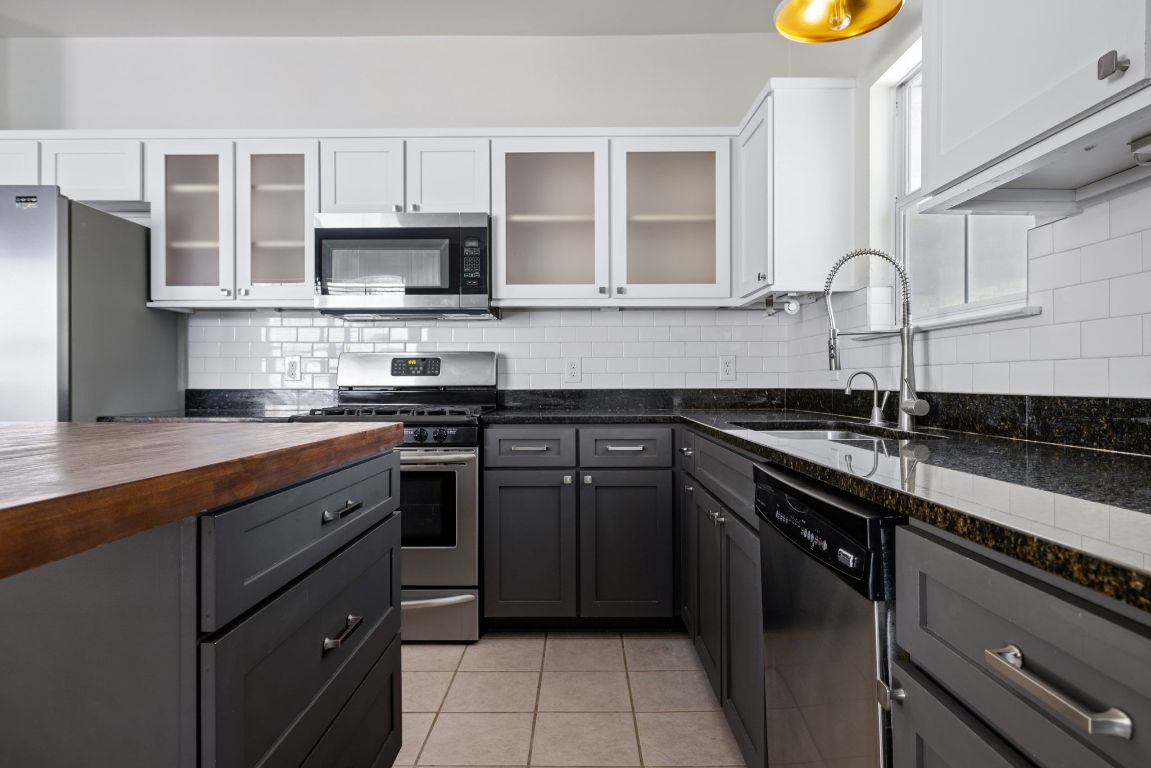 9324 Muskberry Cove Austin, TX 78717 - Photo 10 of 26 a kitchen with stainless steel appliances granite countertop a sink stove and refrigerator