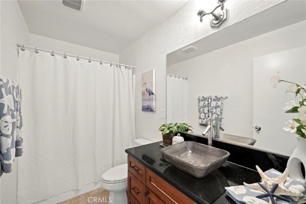 63 Streamwood Irvine, CA 92620 - Photo 15 of 36 Remodeled bathroom offers a tub-and-shower combination and newer vanity with a vessel sink.