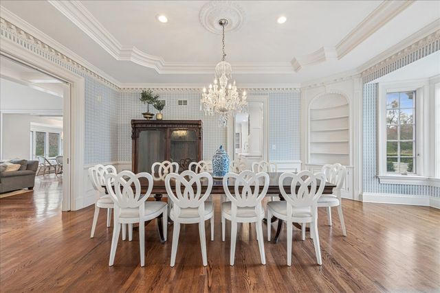 a living room with furniture a fireplace and a chandelier
