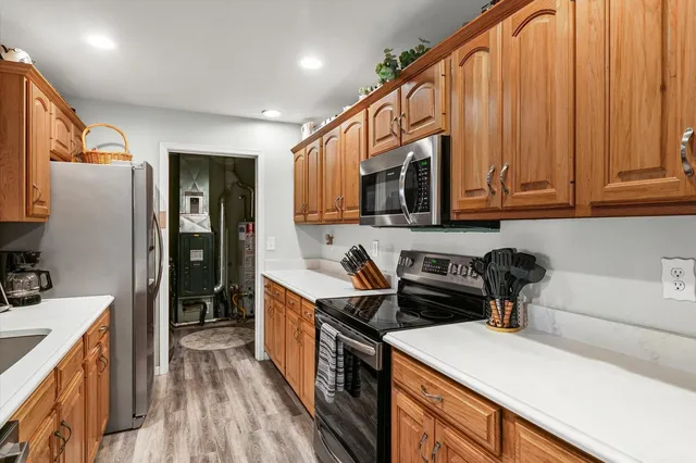 a kitchen with stainless steel appliances granite countertop a sink stove refrigerator and cabinets