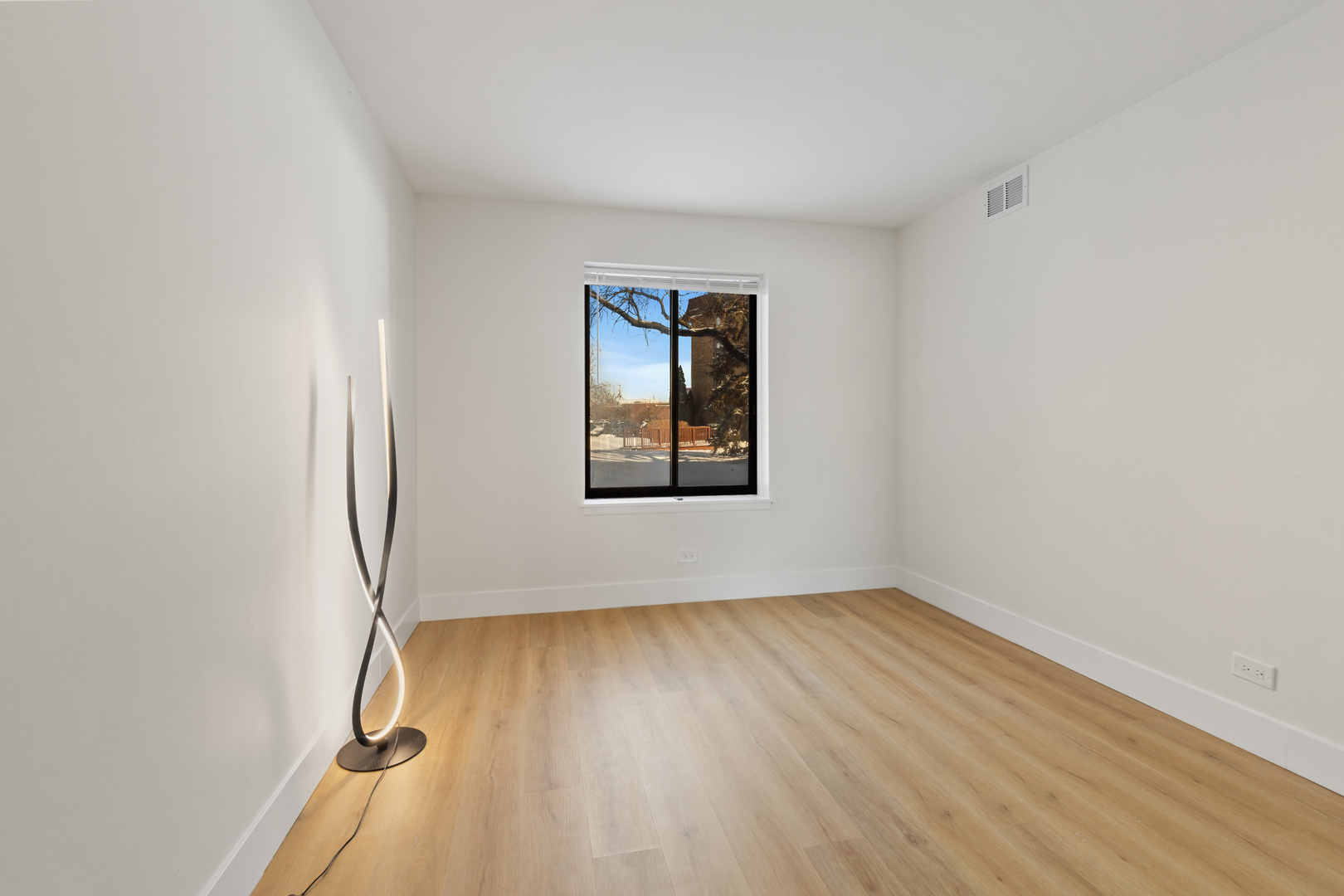 830 Elder Road, Unit B104 Homewood, IL 60430 - Photo 17 of 19 an empty room with wooden floor and windows