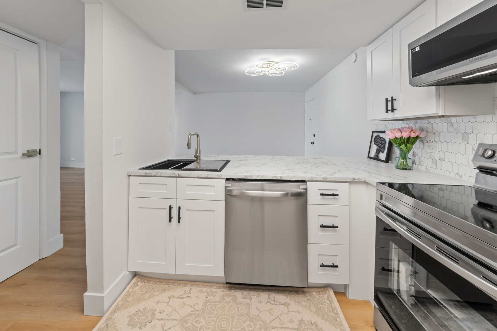 830 Elder Road, Unit B104 Homewood, IL 60430 - Photo 6 of 19 a kitchen with white cabinets stainless steel appliances and sink