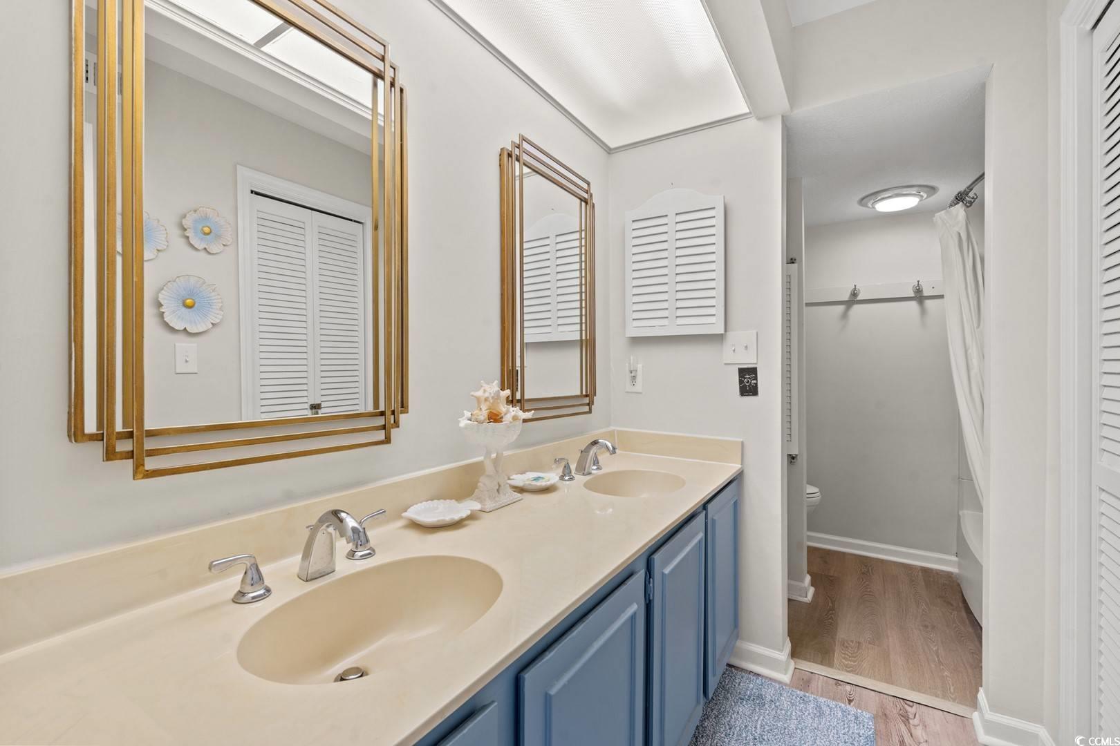 5507 North Ocean Boulevard, Unit 113 Myrtle Beach, SC 29577 - Photo 11 of 28 Bathroom featuring double vanity, light wood-type flooring, and shower / bath combo