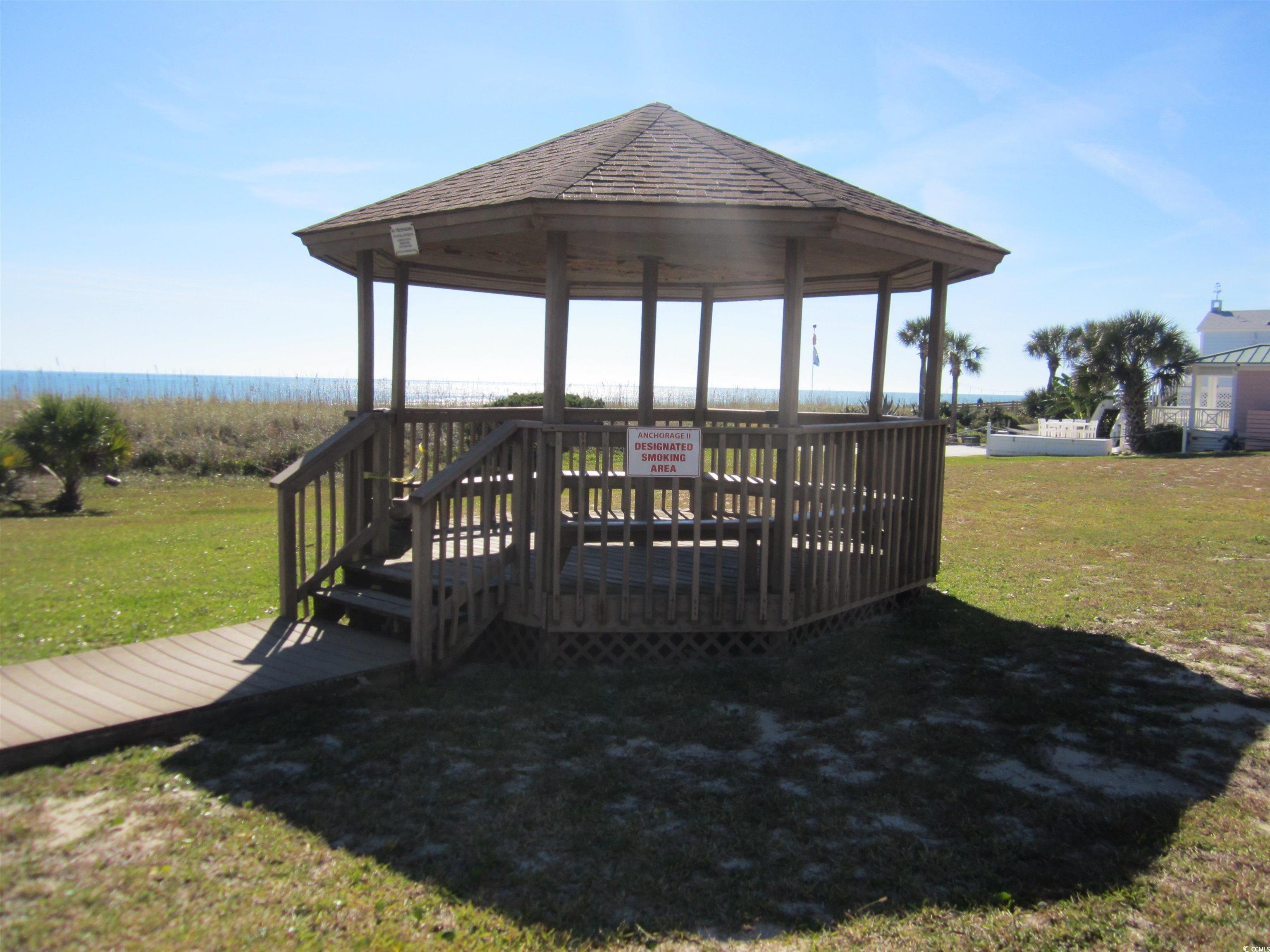5507 North Ocean Boulevard, Unit 113 Myrtle Beach, SC 29577 - Photo 20 of 28 Wooden terrace with a gazebo and a yard