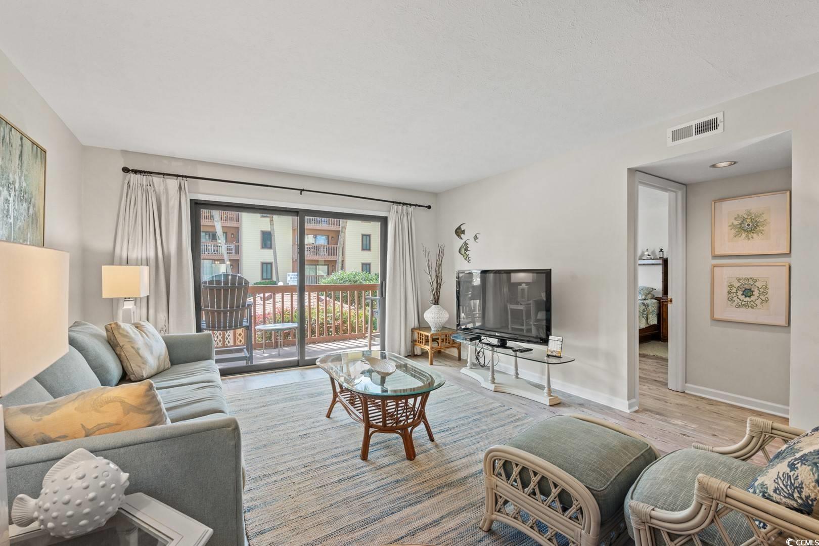 5507 North Ocean Boulevard, Unit 113 Myrtle Beach, SC 29577 - Photo 4 of 28 Living area with wood finished floors and baseboards