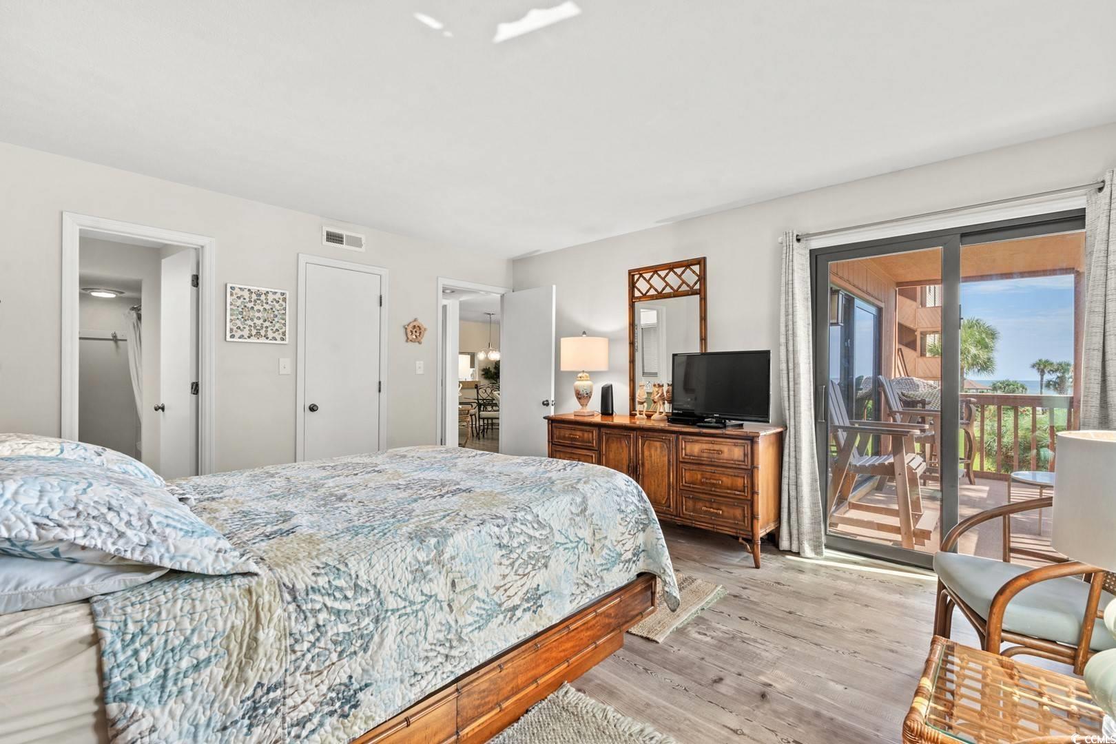 5507 North Ocean Boulevard, Unit 113 Myrtle Beach, SC 29577 - Photo 10 of 28 Bedroom with wood finished floors and access to outside