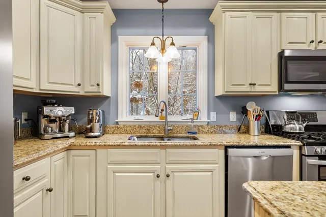 a kitchen with stainless steel appliances granite countertop a sink stove and white cabinets