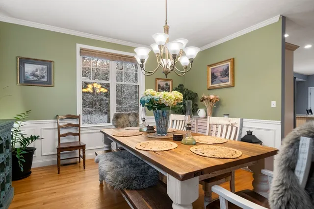 a view of a dining room with furniture a chandelier and wooden floor