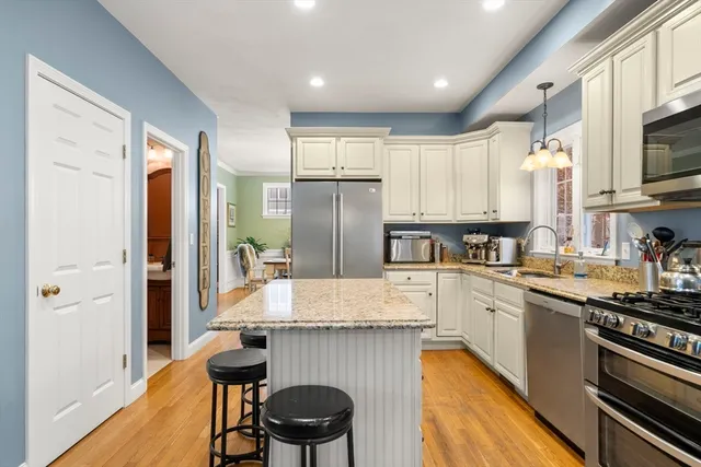 a kitchen with stainless steel appliances granite countertop a refrigerator and a stove top oven